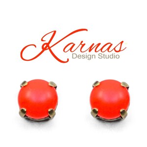 May include: A pair of small, round, orange stud earrings with a bronze setting.