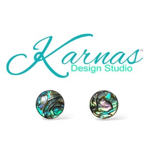 Könnte beinhalten: Ein Paar runde Ohrstecker aus Abalone-Muscheln. Die Ohrringe zeigen schillernde Blau-, Grün- und Lilatöne. Der Text "Karnas Design Studio" befindet sich über den Ohrringen.