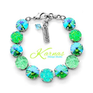 May include: A silver bracelet with alternating green and blue crystal beads. The bracelet has a silver clasp and a small tag with the text "Karnas Design Studio".