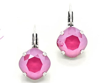 May include: A pair of silver dangle earrings with pink crystal stones. The earrings are from the Karmas Design Studio.
