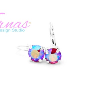 May include: A pair of silver earrings with iridescent purple and red round stones. The earrings have a hook closure.