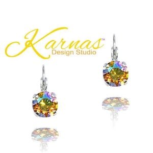 May include: A pair of silver dangle earrings with iridescent yellow and orange crystal stones. The earrings are from Karnas Design Studio.