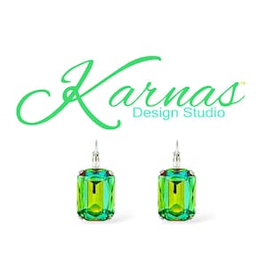 May include: A pair of green and blue emerald-cut crystal earrings with silver hooks. The earrings are from Karnas Design Studio.