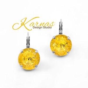 May include: A pair of silver earrings with yellow glass stones. The earrings have a lever back closure.