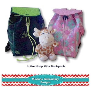 May include: Two children's backpacks, one dark green with a camouflage pattern and the other pink with a floral design, are displayed with a stuffed giraffe. The backpacks have drawstring closures. The text "In the Hoop Kids Backpack" is visible.