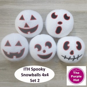 May include: Set of five white plush snowballs with embroidered Halloween faces. The faces include a pumpkin, a ghost, and three different variations of a skull. The snowballs are arranged in a circle on a woodgrain surface. The text "ITH Spooky Snowballs 4x4 Set 2" is below the snowballs. A pink circle with the text "The Purple Hat" is in the lower right corner.