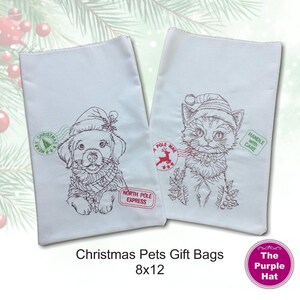 May include: Two white fabric gift bags measuring 8 by 12 inches. One bag features an embroidered puppy wearing a Santa hat with a green Merry Christmas stamp and a red North Pole Express label. The other bag shows an embroidered kitten in a Santa hat with a red North Pole Mail stamp and a green Handle With Care label.