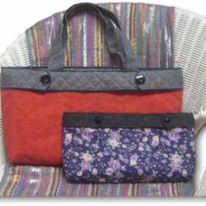 May include: A large red tote bag with a grey quilted top band and two handles, paired with a smaller rectangular pouch featuring a dark blue floral print and a matching grey quilted top band. Both items feature two black buttons on the front.