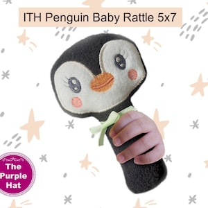 May include: A black and white penguin baby rattle with a green bow. The rattle is 5 inches by 7 inches.