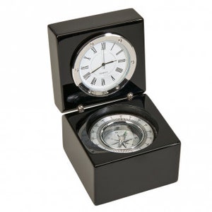 May include: A black wooden box with a hinged lid, revealing a compass and a clock. The clock has a white face with black Roman numeral markings and silver hands. The compass has a silver needle and a white face with black markings.