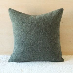 May include: A dark green square pillow with a soft, textured fabric.