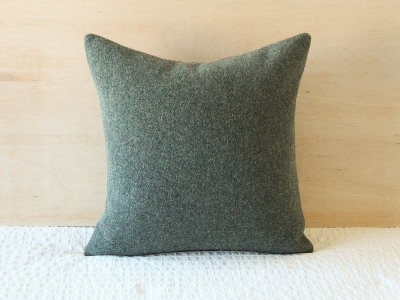 May include: A dark green square pillow with a soft, textured fabric.