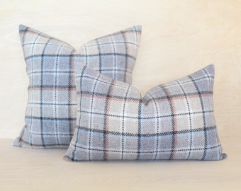 May include: Two decorative throw pillows with a grey, blue and beige plaid pattern.