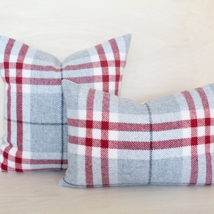 May include: Two decorative throw pillows with a red and white plaid pattern on a gray background.