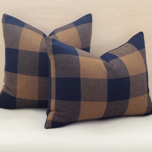 May include: Two decorative throw pillows with a blue and brown plaid pattern.