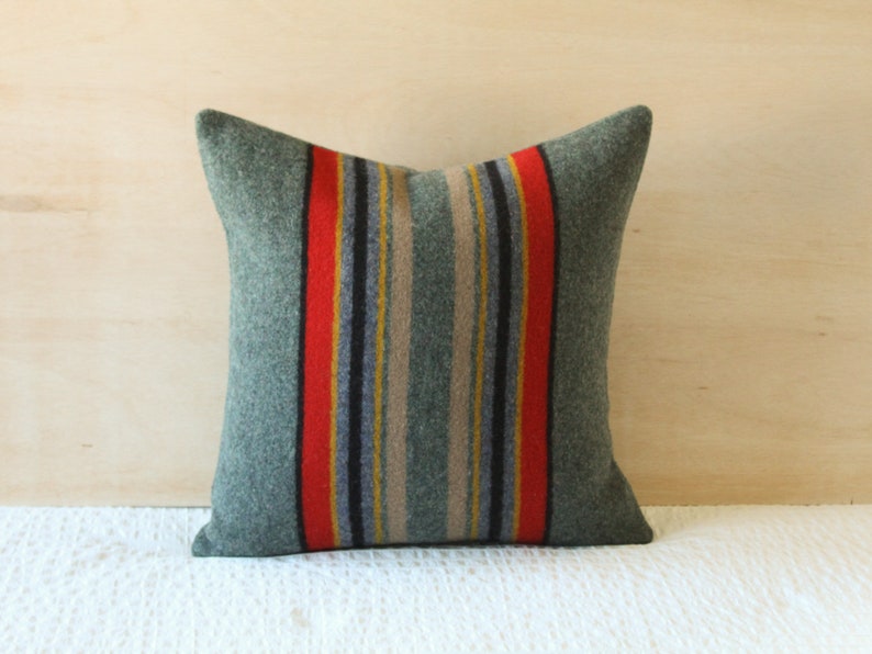 May include: A green and red striped throw pillow with a woven texture. The pillow is made of a soft, comfortable material and is perfect for adding a touch of style to any room.