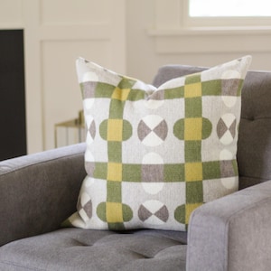 May include: A gray armchair with a throw pillow featuring a geometric pattern of green, yellow, and white circles and squares.
