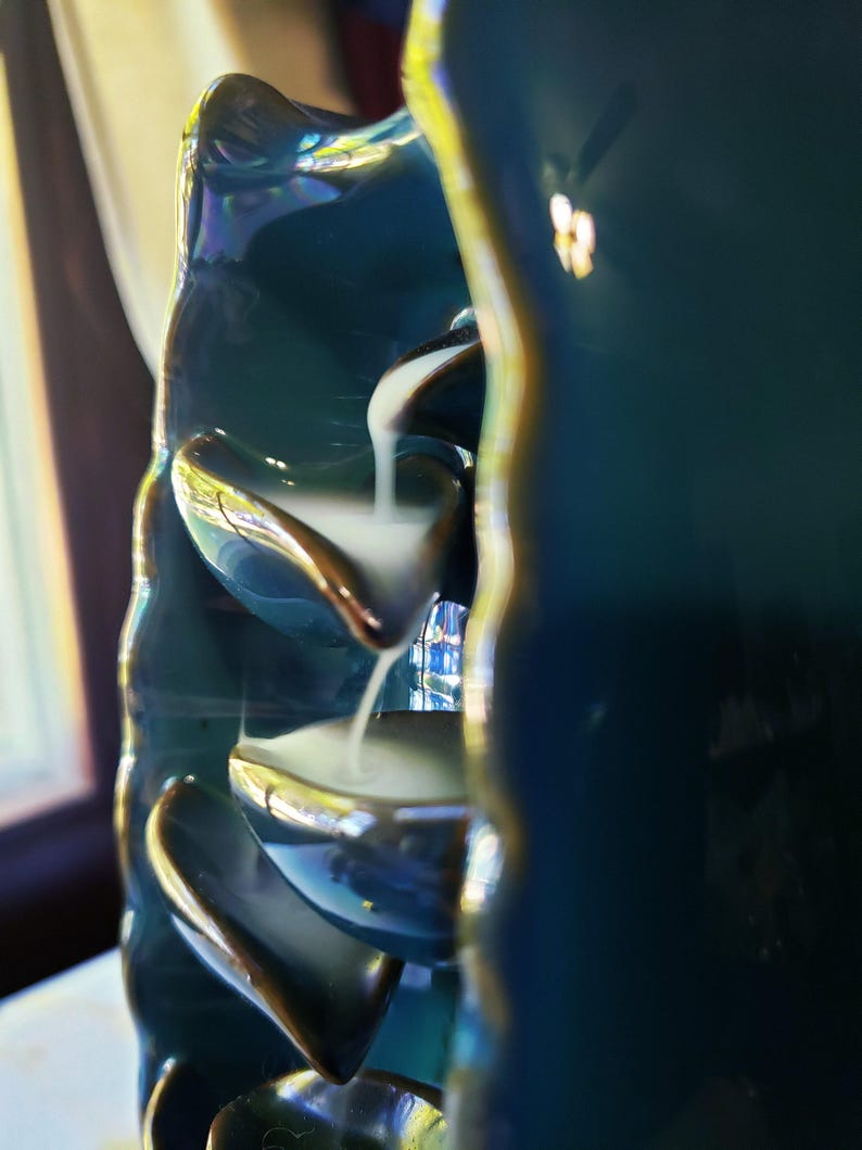 A close-up view of a blue ceramic fountain with water flowing down its sides, creating a serene and calming atmosphere.
