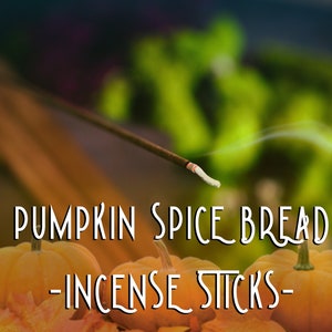 May include: Pumpkin spice bread incense sticks with a smoky aroma. The sticks are burning and the smoke is rising. The sticks are surrounded by fall leaves and pumpkins.