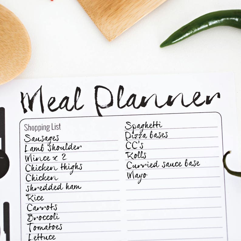 K&ouml;nnte beinhalten: Ein wei&szlig;er Essensplaner mit einem schwarzen handschriftlichen Titel "Meal Planner" und einer Einkaufsliste mit Artikeln wie W&uuml;rstchen, Lammschulter, Hackfleisch, H&auml;hnchenschenkel, H&auml;hnchen, geschnittenem Schinken, Reis, Karotten, Brokkoli, Tomaten und Salat. Die rechte Seite der Seite listet Essensideen wie Spaghetti, Pizzab&ouml;den, CC's, Br&ouml;tchen, Curry-So&szlig;enbasis und Mayonnaise auf.