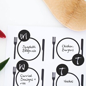 K&ouml;nnte beinhalten: Schwarz-wei&szlig;e druckbare Platzkarte mit einem Design aus Gabel, Messer und Teller. Die Platzkarte sind mit verschiedenen Speiseoptionen beschriftet: Spaghetti Bolognese, Chicken Burger, Currywurst + Reis und Nachos.