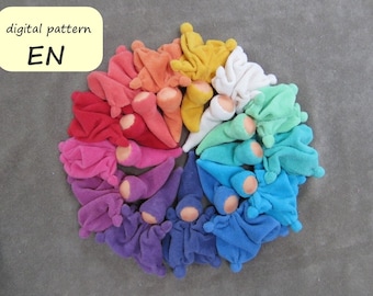 Può includere: Un arcobaleno di colori in un cerchio di bambole di stoffa fatte a mano. Ogni bambola è fatta di stoffa morbida e colorata e ha una piccola testa rotonda. Le bambole sono disposte in cerchio, con i colori dell'arcobaleno.