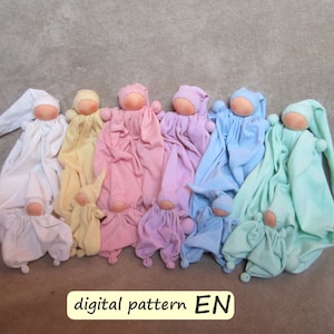 May include: A set of ten handmade fabric dolls in various pastel colors, including white, yellow, pink, light blue, and green. Each doll has a simple, rounded face and a small, pointed hat. The dolls are arranged in a row, with the largest doll at the left and the smallest doll at the right. The dolls are all wearing simple, loose-fitting clothing. The text "digital pattern EN" is visible at the bottom of the image.