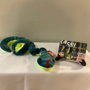 May include: Green and yellow beanie baby snake named "Litssy" with a red tongue. The tag reads "Beanie Babies Series 1 418 1996".