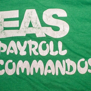 May include: Green t-shirt with white text that reads "EAS PAYROLL COMMANDOS".
