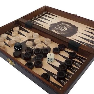Può includere: Un set da gioco di backgammon in legno con un design a leone sul tabellone. Il set include pedine bianche e nere e due dadi.