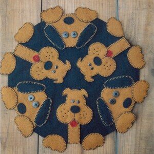 Peut inclure: Un tapis rond en feutre avec un fond bleu foncé et six chiens en feutre marron avec des yeux et des nez noirs. Les chiens sont disposés en cercle autour du tapis, leurs queues pointant vers le centre.