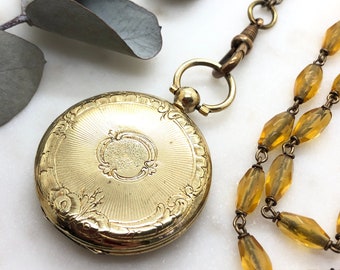 Antico medaglione in oro laminato su collana a guardia lunga in vetro