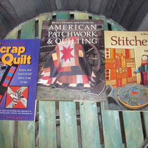 May include: Three quilting and embroidery books with colorful covers. The first book is titled "Scrap Quilt" and features a patchwork quilt design. The second book is titled "American Patchwork & Quilting" and features a red, white, and brown quilt. The third book is titled "Stitchery" and features a colorful embroidery design.