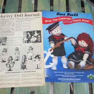 May include: A vintage magazine ad for Cabbage Patch Kids dolls. The ad features two dolls dressed in sailor outfits, holding a rope and an anchor. The text reads "Set Sail With The Cabbage Patch Kids!"