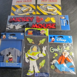 May include: A set of six Disney character sticker packs. The packs feature Mickey Mouse, Toy Story's Buzz Lightyear, and Goofy. Each pack includes multiple stickers with different designs and sizes. The stickers are perfect for adding a touch of Disney magic to any project.