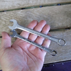 May include: Two silver wrenches, one 3/8 inch and one 1/2 inch, with the brand name "AKE" printed on them.