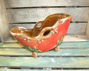 Centro de mesa con portabotellas de vino o champán en forma de trineo navideño de la colección TII vintage, con acebo y bayas y piñas.