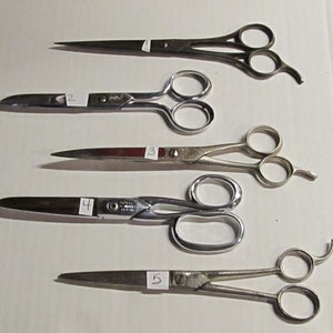 May include: Five different pairs of scissors with silver blades and handles. The scissors are numbered 1 through 5.
