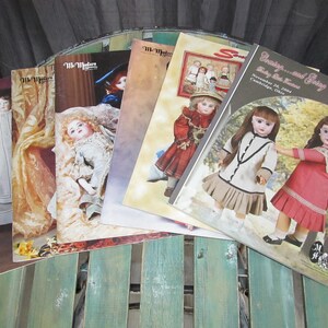 May include: A stack of vintage doll magazines with colorful covers featuring antique dolls. The magazines are titled "The Doll Maker" and "Dressing and Caring for Baby Doll Treasures".
