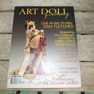 May include: A magazine cover for Art Doll Quarterly featuring a doll dressed in a traditional Japanese kimono. The cover text includes "Doll Artist Profile: DAN FLETCHER", "Answering the Challenge: ALTERED & EMBELLISHED BENDI DOLLS", "New Art Doll Challenge: CELEBRITY LOOK-ALIKE DOLLS", "Fine-Sculpted Wooden Dolls", and "Introducing... THE RED-HAT LADIES!"