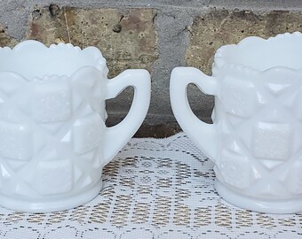 May include: A white milk glass creamer and sugar bowl set with a quilted pattern. The set is in excellent condition and has no chips or cracks.