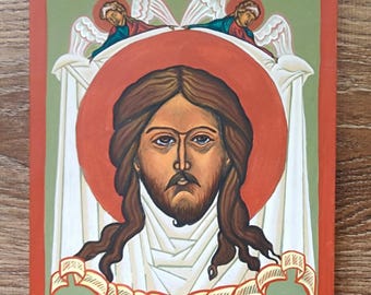 May include: A religious icon featuring a central figure with long brown hair, a beard, and a red halo. Two angels are depicted above the figure. The artwork is framed in red and set against a green background.