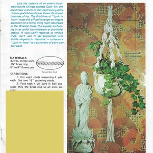 Może przedstawiać: Biały makramowy wieszak na rośliny z frędzlami o długości 23 cm, nazwany "Lyric in Ivory", jest pokazany wiszący z sufitu. Wieszak wykonany jest z bawełnianego sznurka i mosiężnego pierścienia. Instrukcje dotyczące wykonania wieszaka znajdują się na zdjęciu.