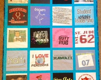 May include: A quilt made from t-shirts with various designs and text. The quilt is made up of 16 squares, each with a different design. Some of the designs include a giraffe, a peacock, a mermaid, a school band logo, and a university logo. The quilt is a great way to commemorate special events or to show off your personality.