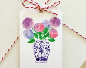 May include: A white gift tag with a blue and white floral design. The tag has a hole at the top for string and says "To:" and "From:" at the bottom.