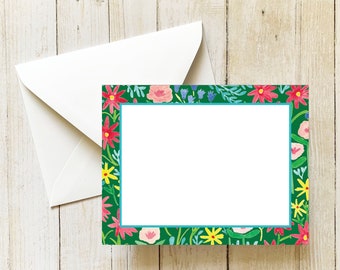 May include: A blank card with a green background and a colorful floral border. The border features pink, red, yellow, and blue flowers.
