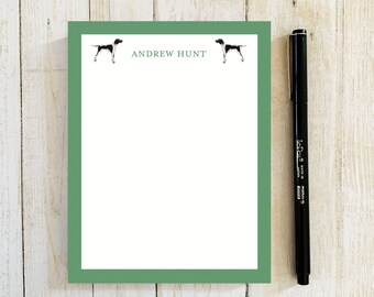 May include: Green notepad with a white interior and a black and white dog illustration on each side. The notepad has the name "ANDREW HUNT" printed at the top.
