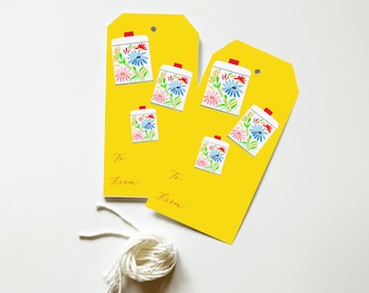 May include: Two yellow gift tags with a hole punched in the top. Each tag has a red, white, and blue floral design and the words "To:" and "From:" printed in red.