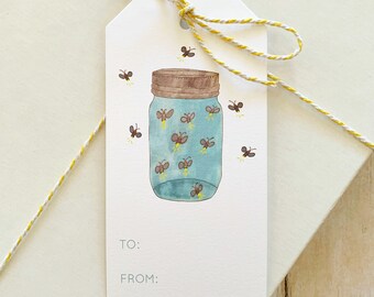 May include: A white gift tag with a blue mason jar filled with glowing fireflies. The jar has a brown lid and there are fireflies flying around it. The tag has the words "TO:" and "FROM:" printed on it.