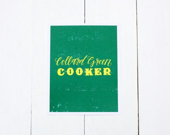 May include: A green card with the text "Collard Green COOKER" in yellow lettering. The background has a distressed texture.